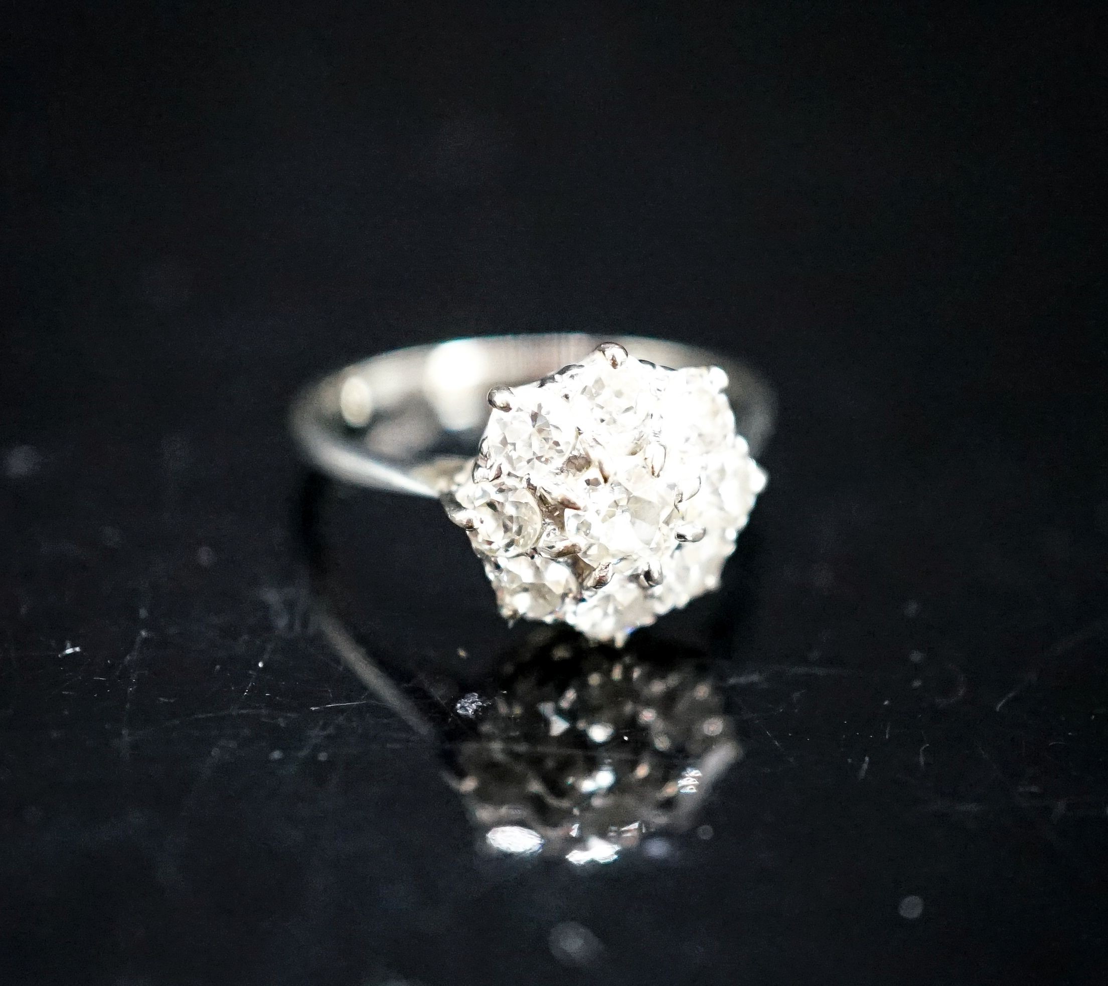 A white metal and diamond cluster ring, size J, gross 2 grams.